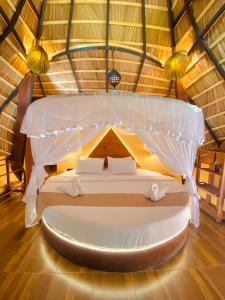 坦加拉Igabara Hobbit House的房间里的帐篷里的一张床位