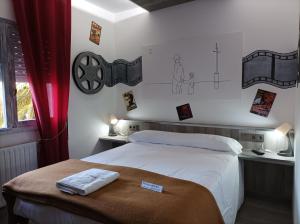 贝坦索斯La Casona de Betanzos的一间卧室配有一张床,墙上挂着一些图画