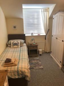 伊斯特布恩Pixie Cottage的一间卧室设有两张床、一张桌子和一个窗口。