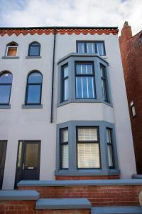 布莱克浦Withnell Stays - Apartment One - Ground Floor的白色的黑窗房子