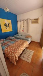 大普拉亚Pousada Charme Charmant的一间卧室设有一张床和蓝色的墙壁