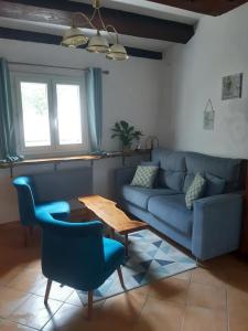 卢贝新城Garden Annexe的客厅配有蓝色的沙发和桌子