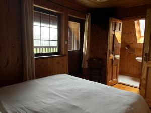 DuneenaCosy Lakeside Chalet With Option to add Private Hot Tub & Boat的一间卧室设有一张大床和一个窗户。