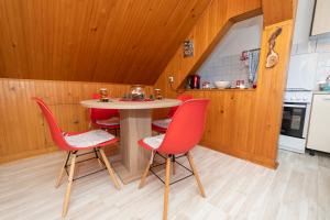 拉夫纳格拉Studio Apartman Poljančić的厨房配有桌子和四把红色椅子