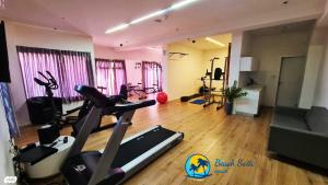 亚实基伦Private Jacuzzi Garden Beach Suite, Gym, 3 Min Walk To Beach דירת גקוזי ספא גינה ענקית 3 דקות הליכה לים וחדר כושר的客厅设有带跑步机的健身房