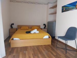 罗德兹Le Bullière 60m2 plein centre!的一间卧室配有一张床和一把椅子
