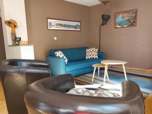 罗德兹Le Bullière 60m2 plein centre!的客厅配有蓝色的沙发和椅子