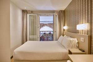 圣地亚哥－德孔波斯特拉Hostal Suso的酒店客房设有床和窗户。