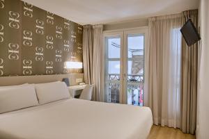 圣地亚哥－德孔波斯特拉Hostal Suso的卧室配有白色的床和窗户。