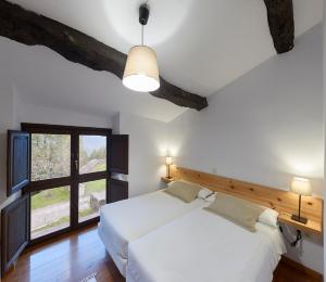 LinaresCasa de Aldea Casina del Naranjo的卧室设有一张白色大床和一扇窗户。