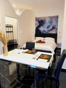巴罗尼西Setteabbracci Suite & Apartments的配有一张床和一张桌子及两把椅子的房间