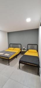 怡保Guesthouse @ Ipoh garden II的配有黄色床单的客房内的两张床