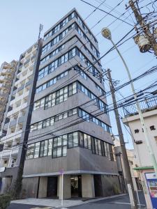 东京PRISM INN OGU的一座高大的灰色建筑,有很多窗户