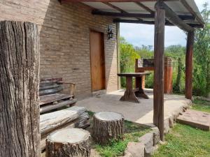 德尔迪克镇EL ZORZAL Dormis con Galeria的一个带木桌和两个木柴的庭院