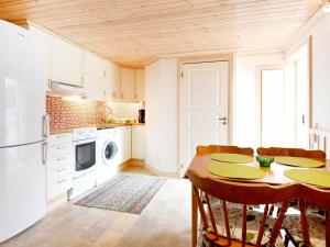 汉堡松德4 person holiday home in Hamburgsund的厨房配有桌椅和冰箱。