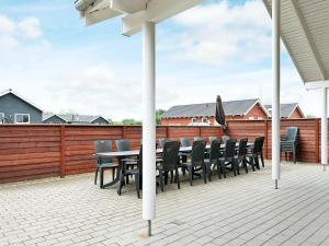 诺德堡18 person holiday home in Nordborg的一个带桌椅和围栏的庭院