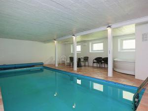 蒂霍尔姆Cozy Holiday Home in Thyholm with Swimming Pool的一个带桌椅的大型游泳池