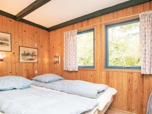 Bøstrup5 person holiday home in H jslev的带2扇窗户的木镶板客房内的2张床