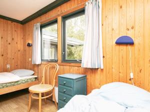 Bøstrup5 person holiday home in H jslev的卧室设有木墙、一张床和窗户