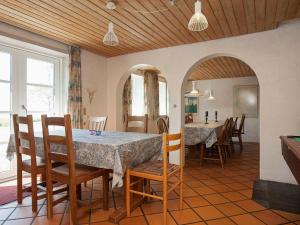 蒂霍尔姆Cozy Holiday Home in Thyholm with Swimming Pool的厨房以及带桌椅的用餐室。