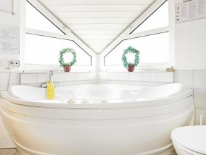 克利特默勒10 person holiday home in Thisted的带浴缸的白色浴室和2扇窗户。