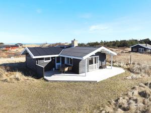 希茨海尔斯Three-Bedroom Holiday home in Hirtshals 4的田野上带太阳能屋顶的房子