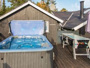 Øksenmølle6 person holiday home in Ebeltoft的桌子旁甲板上的热水浴池