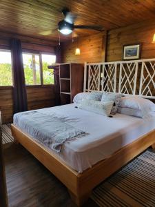 CararaPrivate Mountaintop Cabin in Carara Biological Corridor 20 minutes to beaches的小屋内一间卧室,配有一张大床