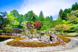 高野山高野山別格本山 总持院的一座拥有岩石和树木的花园以及一座建筑