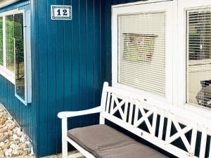 布罗艾厄4 person holiday home in Broager的蓝色房子前面的白色长凳
