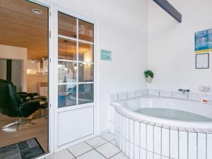 法贾德嘉德18 person holiday home in Ulfborg的一个带椅子的房间的大浴缸