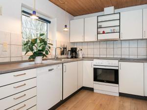 法贾德嘉德18 person holiday home in Ulfborg的白色的厨房配有白色橱柜和窗户