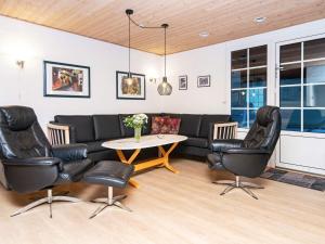 法贾德嘉德18 person holiday home in Ulfborg的客厅配有沙发、椅子和桌子