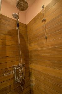 阿诺佩蒂纳Pirrion Wellness Boutique Hotel的带淋浴的浴室和木墙