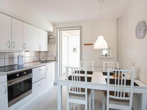 森讷比Holiday home Rømø XI的厨房配有白色橱柜和桌椅
