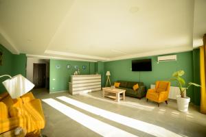 库塔伊西Lemon的客厅设有绿色的墙壁和黄色的椅子