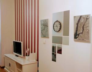 萨拉戈萨JUNTO AL PILAR的配有电视和墙上的时钟的房间
