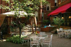 匹兹堡普里奥里酒店的一个带桌椅和遮阳伞的庭院