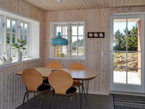 凡岛4 person holiday home in Fan的一间带木桌和椅子的用餐室