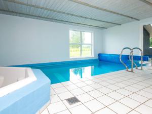 诺德堡Holiday Home Straumen的带浴缸和游泳池的大型浴室