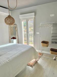 贝哈尔El Rinconcito de Bejar的白色的卧室设有一张大床和一个窗户