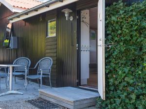 森讷比5 person holiday home in Juelsminde的通往带椅子和桌子的房子的开放式门