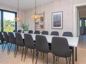 格莱斯堡16 person holiday home in Glesborg的一间配备有白色桌椅的用餐室