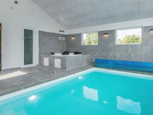 格莱斯堡16 person holiday home in Glesborg的客房内设有一个大型游泳池及浴缸