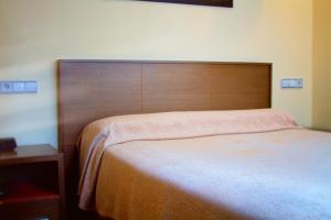 拉科鲁尼亚Hotel Santa Catalina by Bossh Hotels的一张带木制床头板的床