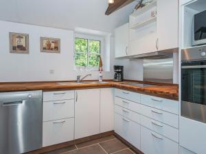 安斯艾厄6 person holiday home in Ansager的厨房配有白色橱柜和水槽