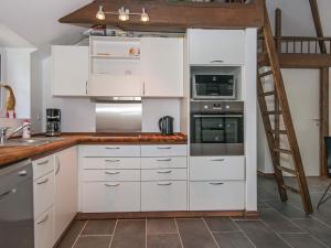 安斯艾厄6 person holiday home in Ansager的厨房配有白色橱柜和梯子