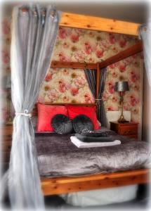 LlanegrynPeniarth arms的一间卧室配有一张带红色枕头的天蓬床