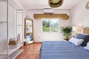 伊维萨镇THE LOVELY VILLA IBIZA的一间卧室配有蓝色的床和镜子