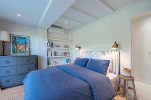 圣特罗佩LA PAUSA, Maison de ville avec Jardin centre de SAINT TROPEZ的一间卧室配有蓝色的床和蓝色梳妆台